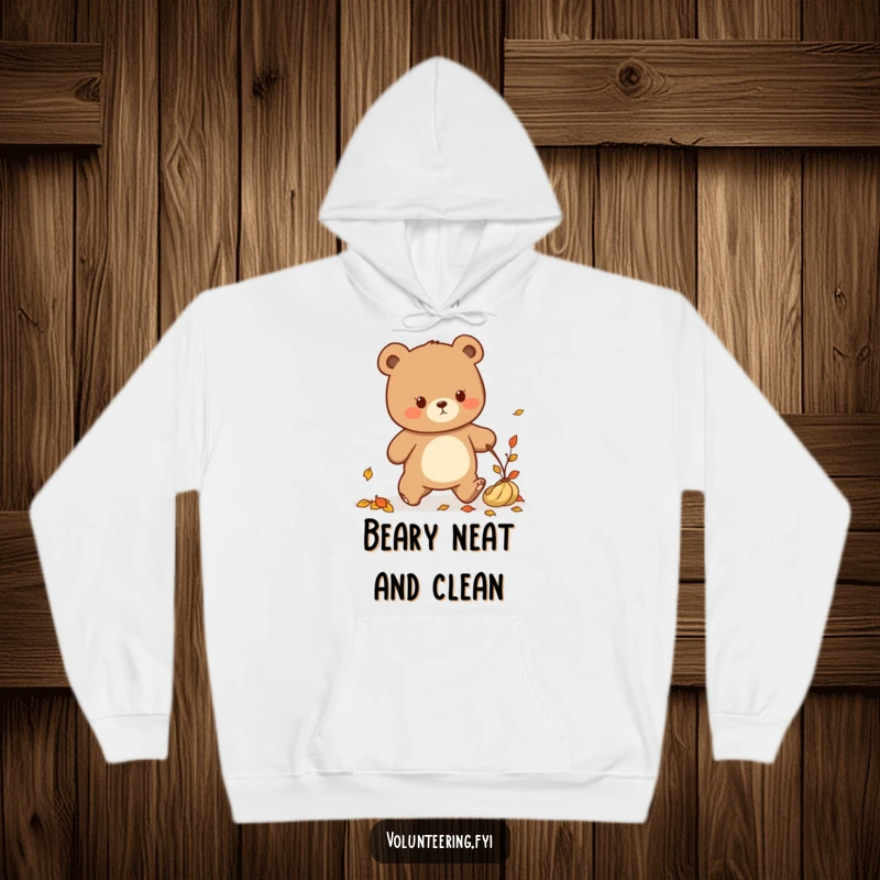 Funny Kawaii bear tidying up fallen leaves, cozy hoodie, cute autumn design.