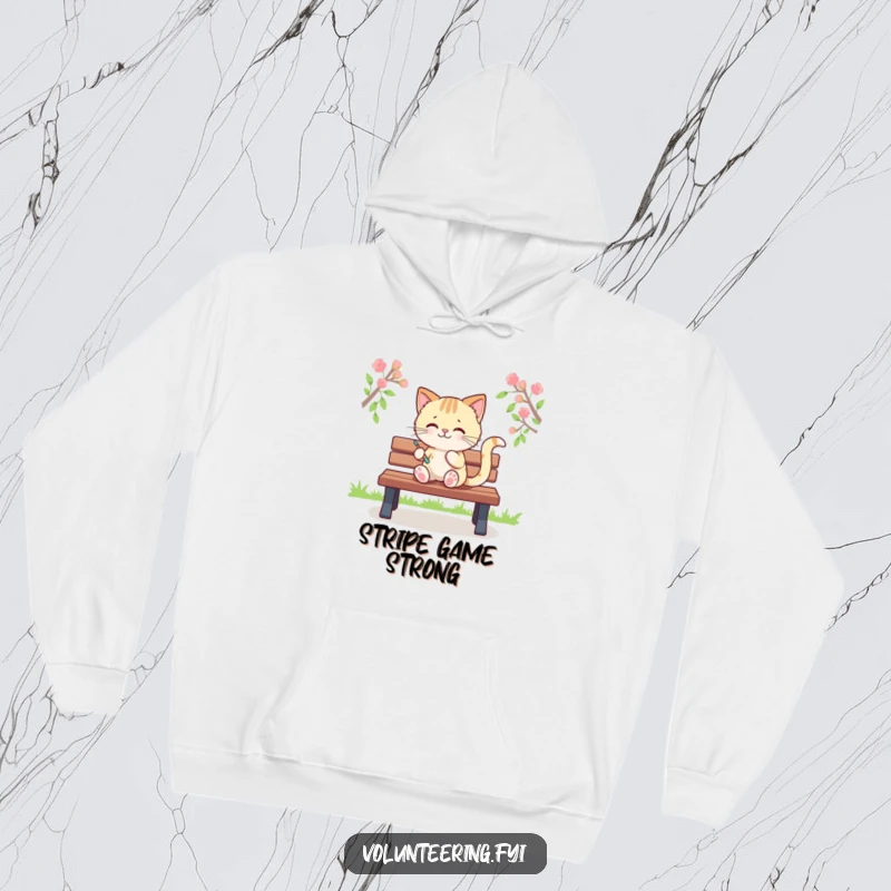 Funny hoodie showcasing a Kawaii cat character diligently painting colorful stripes on a park bench, cozy and humorous apparel.