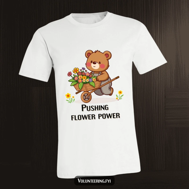 Funny T-Shirt: Determined brown bear in overalls enthusiastically pushes a wheelbarrow filled with colorful flowers, showing enthusiasm.